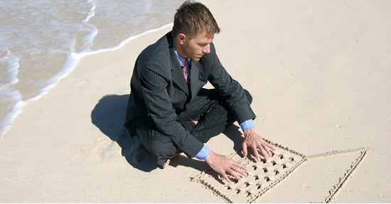 So muss arbeiten am Strand aussehen – schön Krawatte, Anzug und Notebook im Sand.